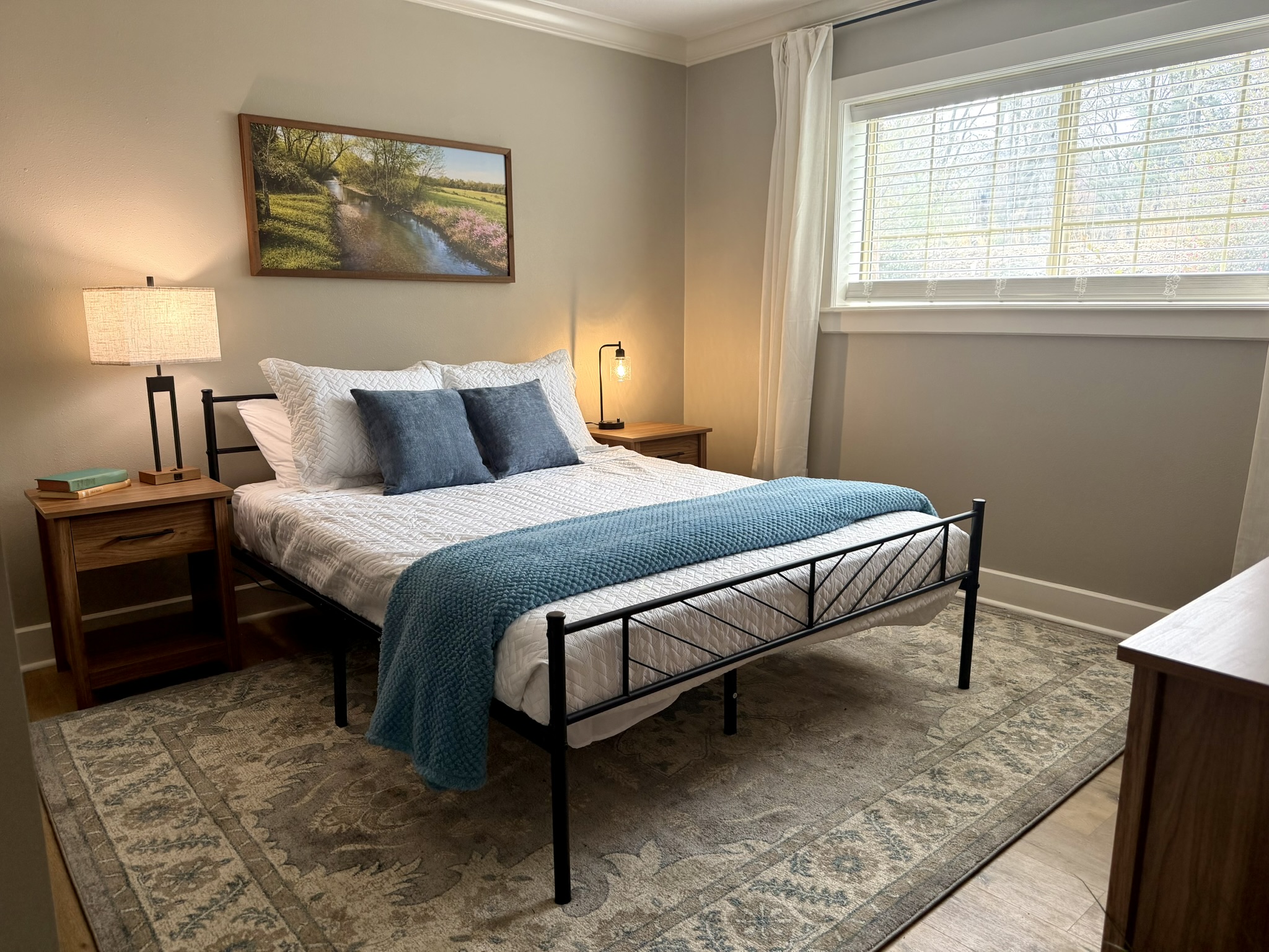 Southern Delight second bedroom with queen bed and landscape painting