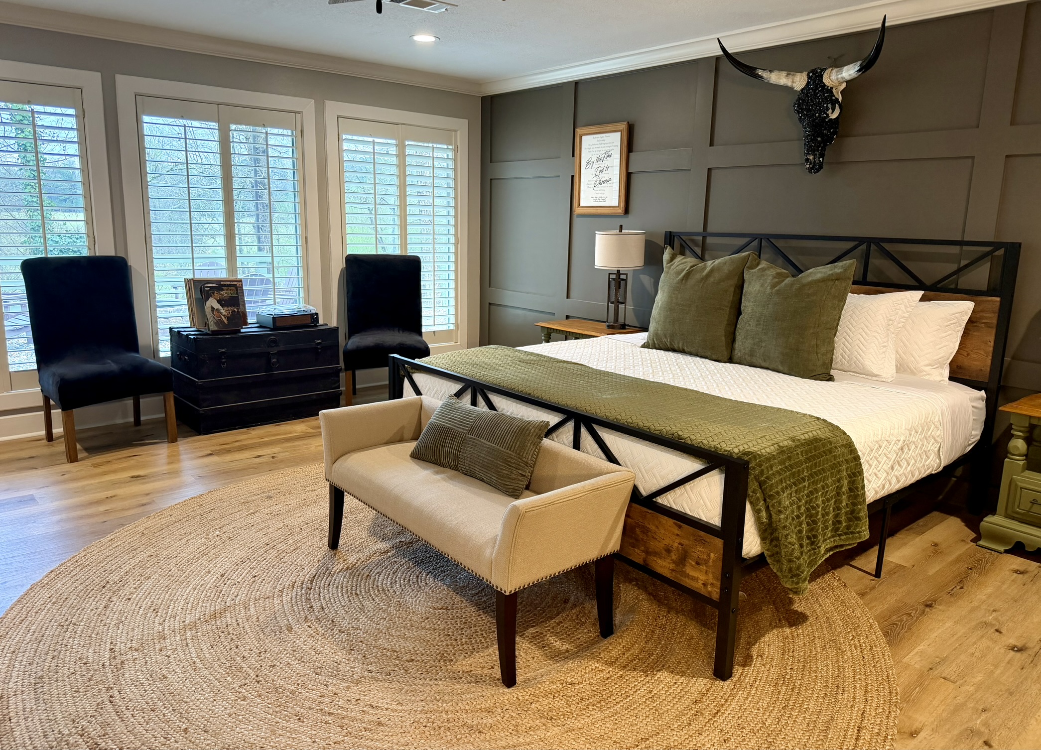 Living area seating with blue armchairs ottoman and longhorn wall mount