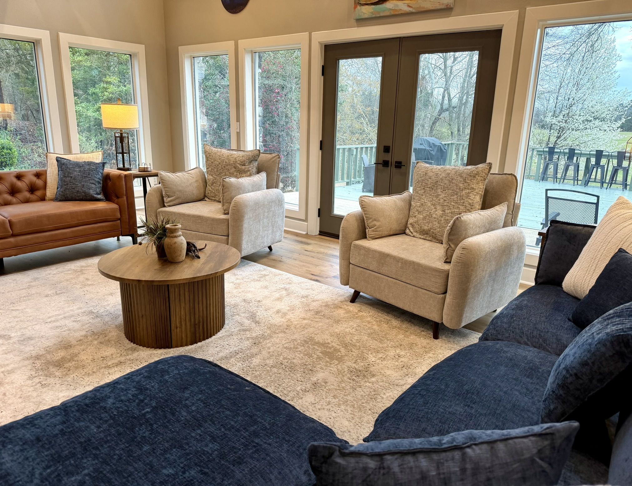 Cozy sitting area with armchairs round wood table and window views of the trees
