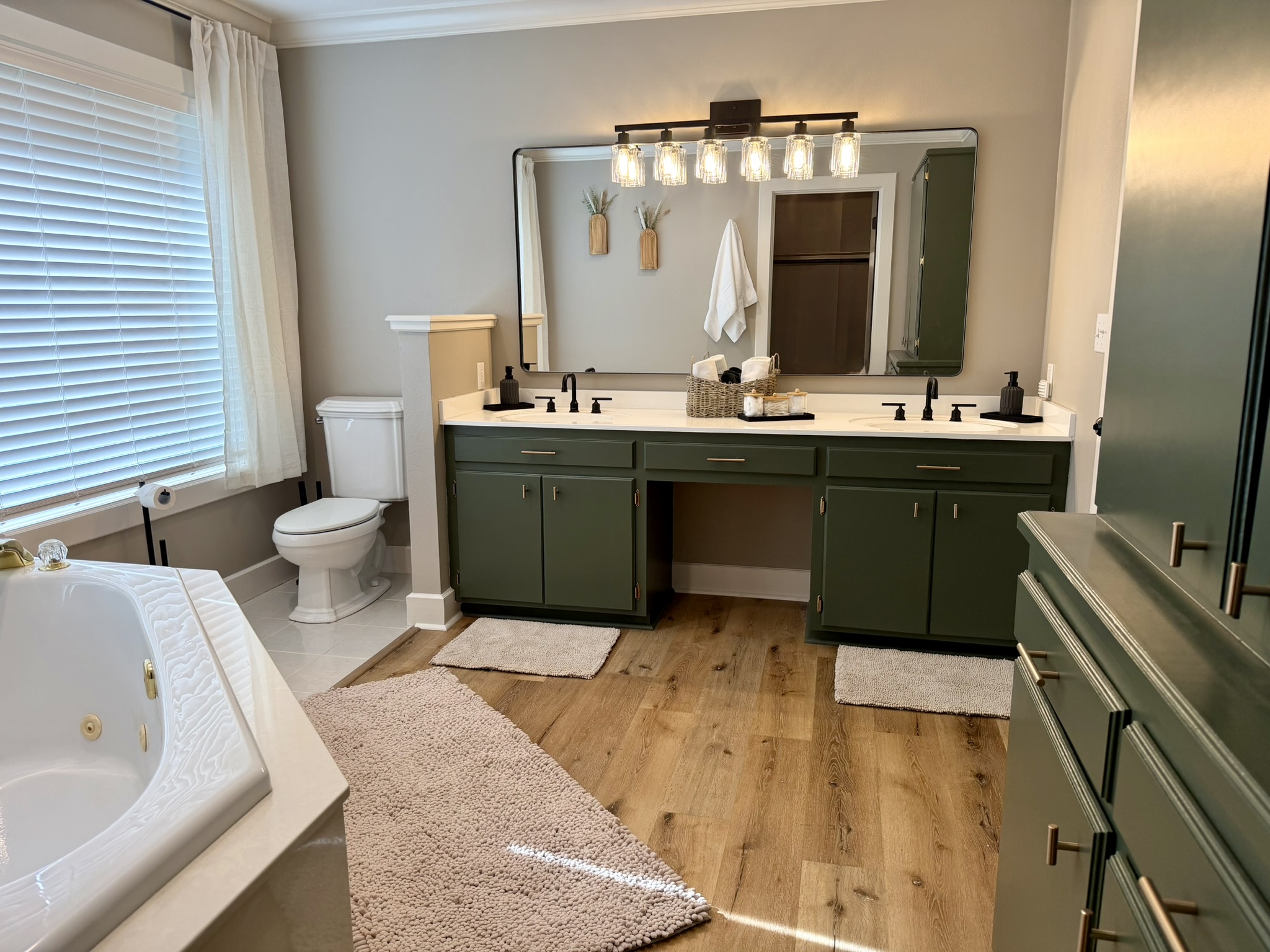Southern Delight primary en suite bathroom with green vanity double sinks and jetted tub
