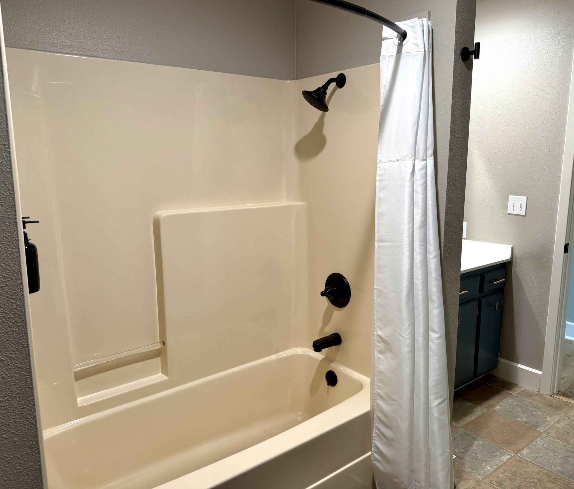 Tub and shower combo with oil rubbed bronze fixtures and white curtain