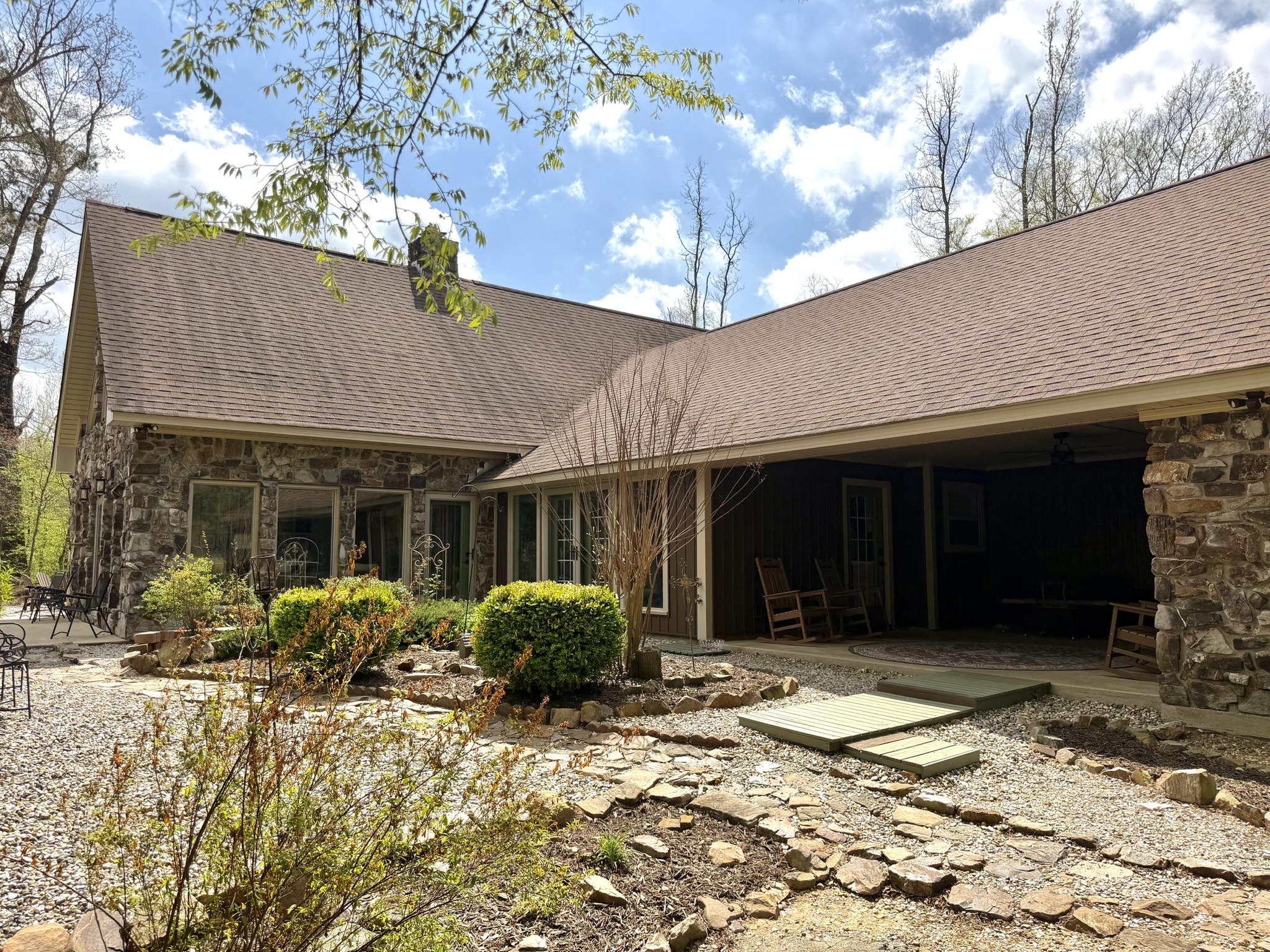 Southern Delight stone exterior with covered porch rocking chairs and landscaped walkway