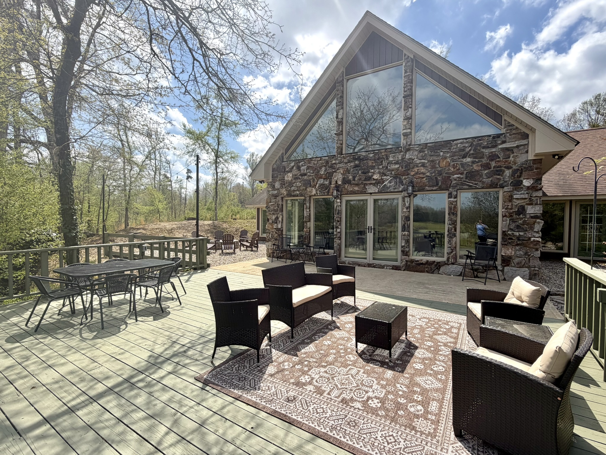 Southern Delight spacious back deck with outdoor seating and stone exterior