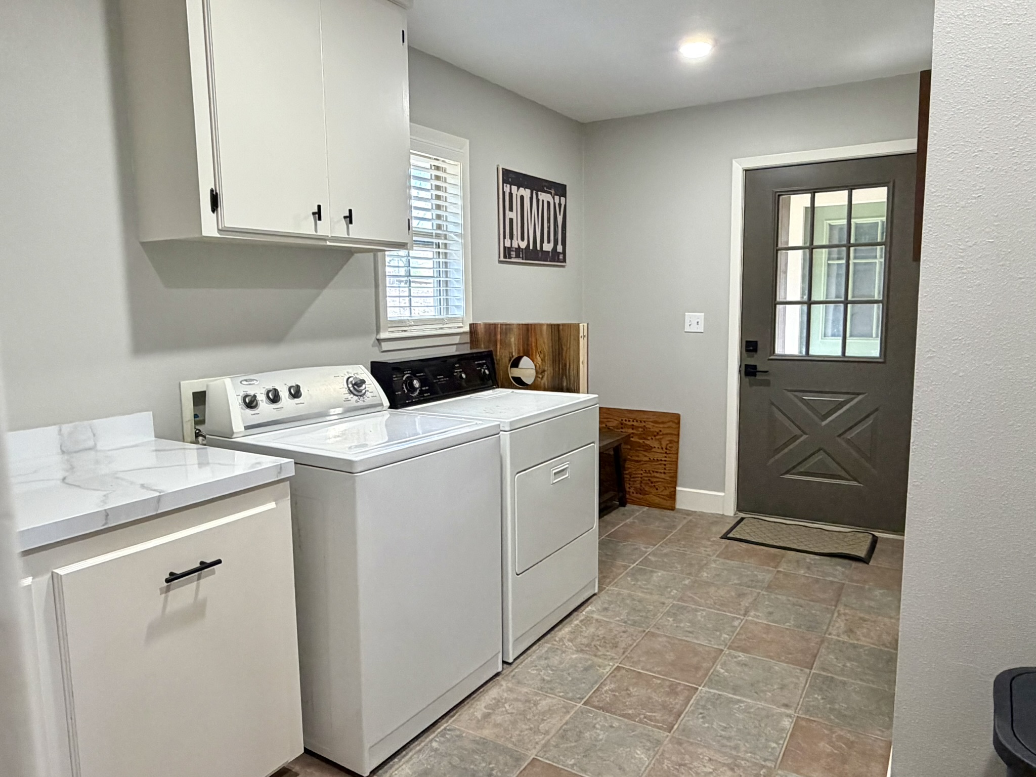 Laundry room with washer dryer Howdy sign and farmhouse style X door