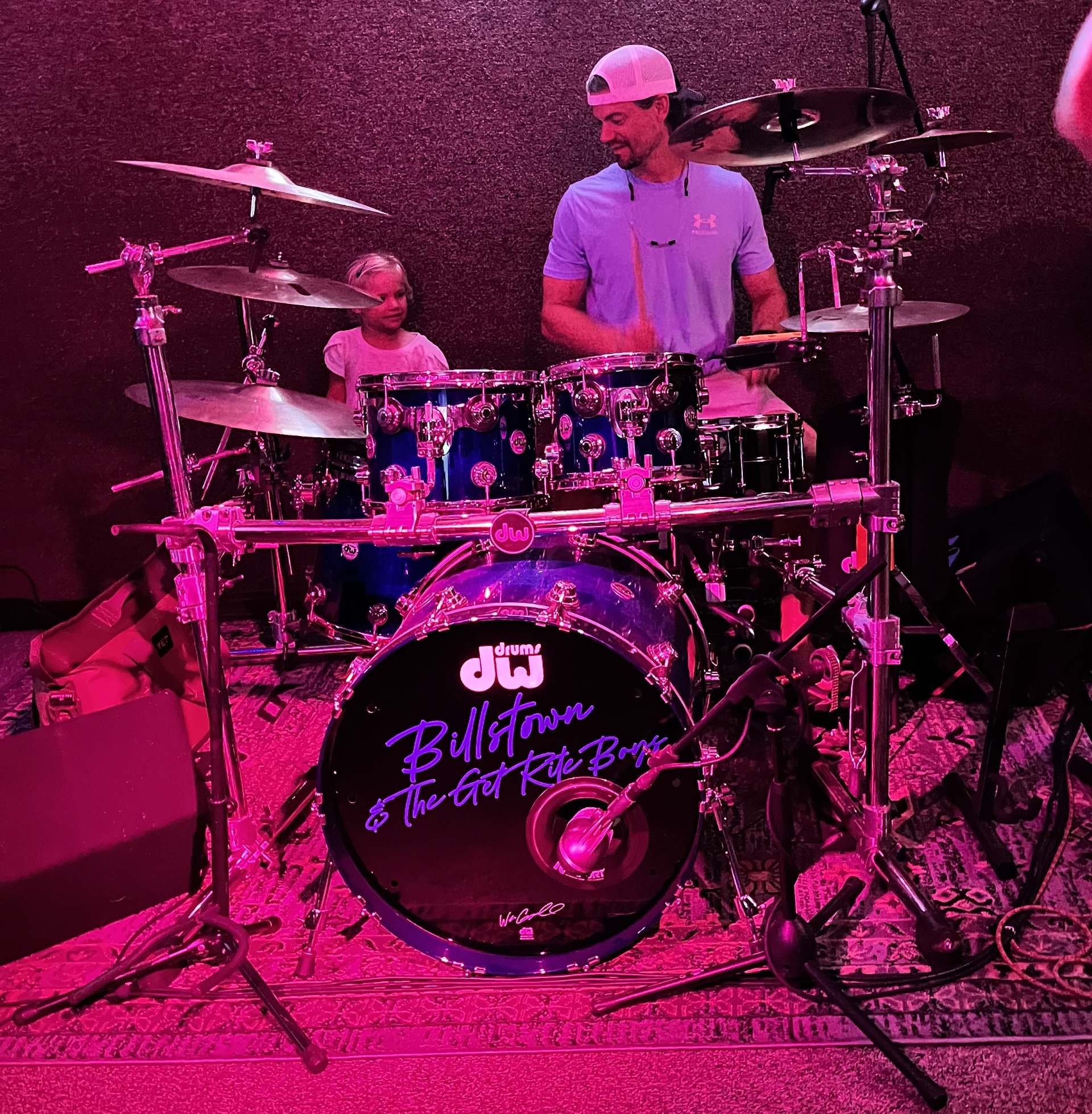 Sean playing drums with Billstown and The Get Rite Boys with his daughter watching beside him